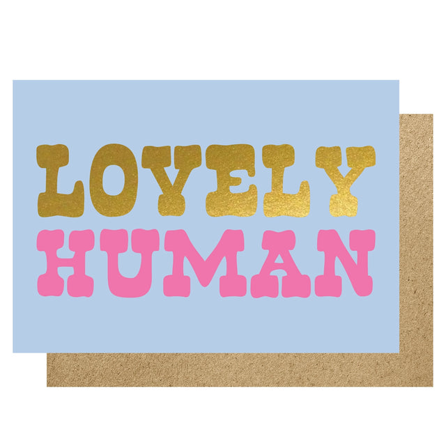 Card with 'Lovely Human' text in gold and pink on a light blue background